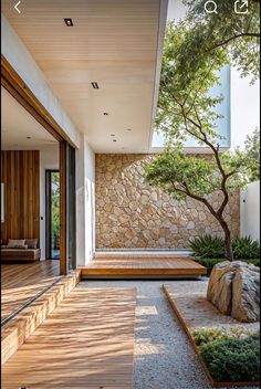 an outdoor area with stone walls and wooden steps leading up to a tree in the center