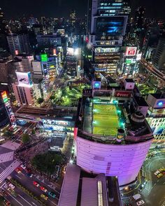 an aerial view of a city at night with lots of lights and buildings in the background