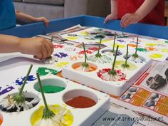 two children are painting flowers with watercolors on the table in front of them