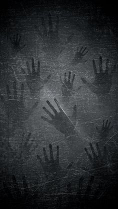 black and white photograph of many hands reaching up in the air to grab something out of the ground