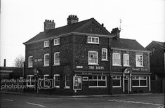 an old black and white photo of the front of a brick building with many windows