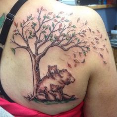 a woman with a bear and tree tattoo on her back