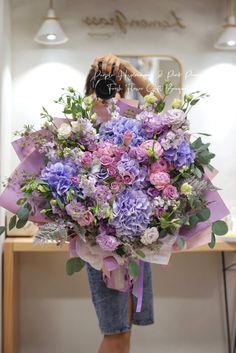 a woman holding a large bouquet of flowers