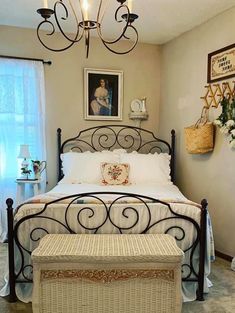 a bedroom with a white bed and a chandelier hanging over it's headboard