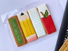 three decorated cookies in the shape of school supplies