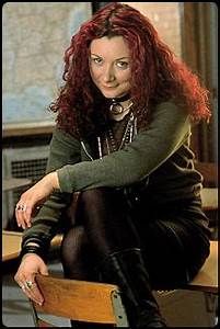 a woman sitting on top of a wooden bench wearing black tights and high heel boots