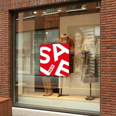 a store window with a sale sign in the front and two mannequins behind it