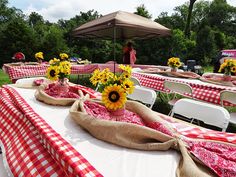 the tables are covered with red and white checkered tablecloths, sunflowers, and burlap bags