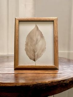 a wooden table with a framed leaf on it