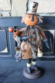 a scarecrow with a pumpkin on his head holding a lantern and wearing a top hat