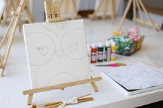 an easel sitting on top of a table with art supplies