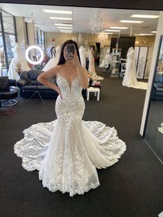 a woman is taking a selfie in her wedding dress at the bridal shop