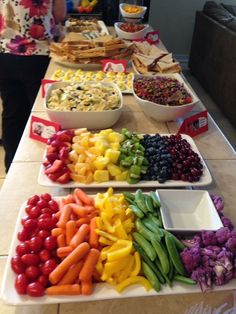 several trays filled with different types of food on top of a long white table