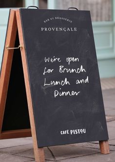 a chalkboard sign with writing on it that reads, we're open for lunch and dinner cafe pistou