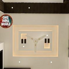 a white clock mounted to the side of a wall in a room with black and white furniture