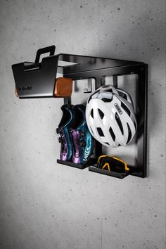 there is a bike helmet, sunglasses and other items in the holder on the wall