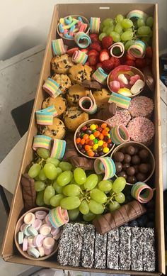 a box filled with lots of different types of food next to candy and candies