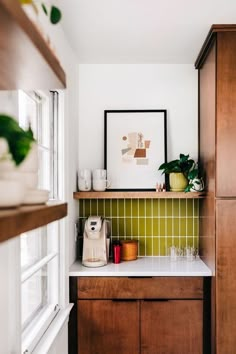 a kitchen with wooden cabinets and green tile backsplashing on the wall above