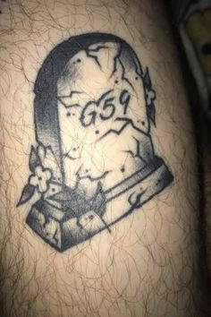 a man's arm with a tattoo on it that has a grave in the middle