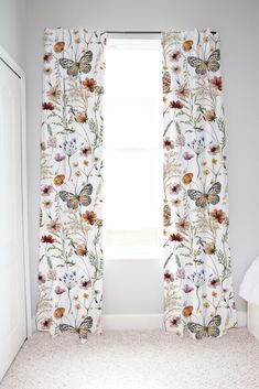 a bedroom with white walls and floral curtains