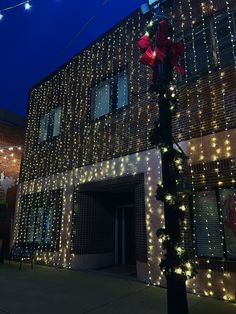 a street light decorated with christmas lights in front of a building