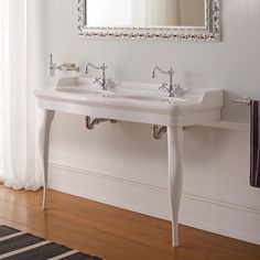 a white sink sitting under a mirror in a bathroom next to a wall mounted faucet