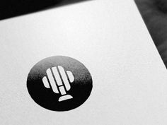 a close up of a white paper with a black and white logo in the middle