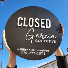 a person holding up a sign that says closed garcia collective