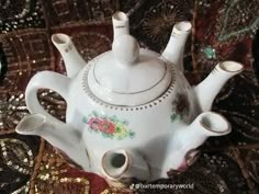 a white tea pot sitting on top of a table