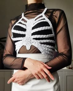 a woman wearing a skeleton top and white skirt