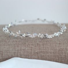 a close up of a tiara on a bed with a pillow in the background