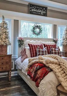 a large bed sitting in a bedroom next to a window with christmas decorations on it