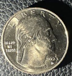 a close up of a coin on a leather surface