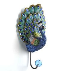 a peacock is hanging on the wall with a hook