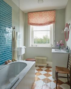 a bathroom with a checkered floor, tub and window in the corner is shown