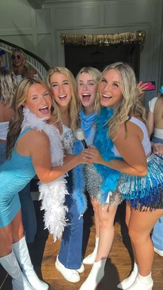 three women in blue and white outfits posing for a photo together at a dance party