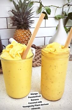 two jars filled with banana pudding next to a pineapple