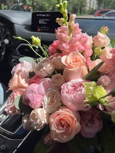 a bouquet of flowers sitting on the dashboard of a car