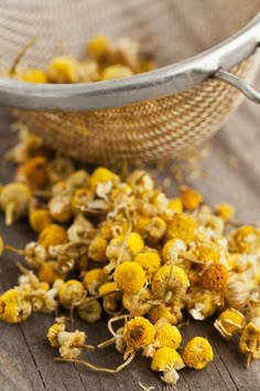 dried flowers in a strainer on a wooden table