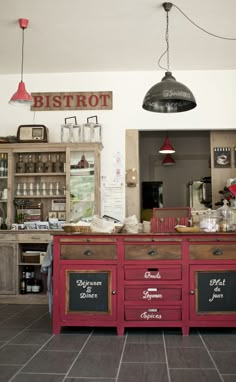 the interior of a restaurant with red cabinets and chalkboard menus on the wall