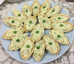 there is a plate full of appetizers with peas in them on the table