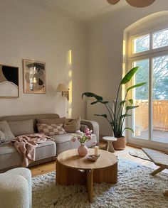 a living room filled with lots of furniture and a large window covered in light shining through