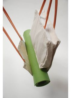 two bags are hanging from the ceiling and one bag is wrapped in green paper with orange handles