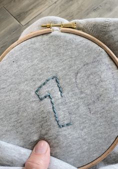 someone is stitching the letter f on a pillow