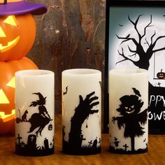 three halloween candles are sitting on a table