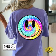 a woman wearing a t - shirt with a tie dye smiley face on the front