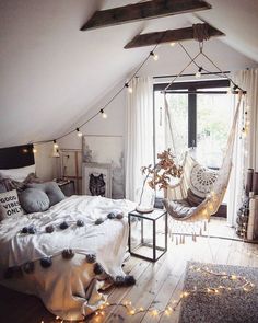 a bedroom with a hammock hanging from the ceiling and lights on the windowsill