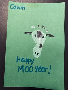 a child's handprint on a piece of paper that says happy moo year