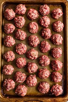 raw meatballs on a baking sheet ready to be cooked in the oven for consumption