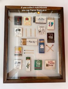 a shadow box filled with matches and matchsticks on top of a white wall